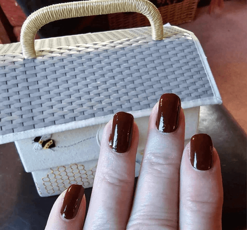Rich coffee brown gel nail wraps on fingers with glossy finish for DIY nail art