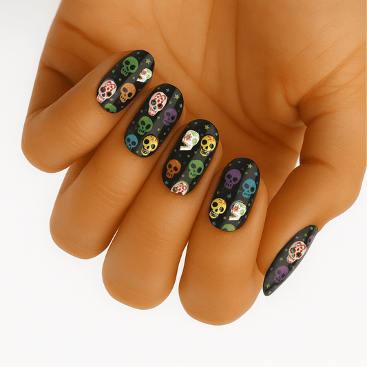 Colourful skull pattern nail wraps on hand featuring Day of the Dead design