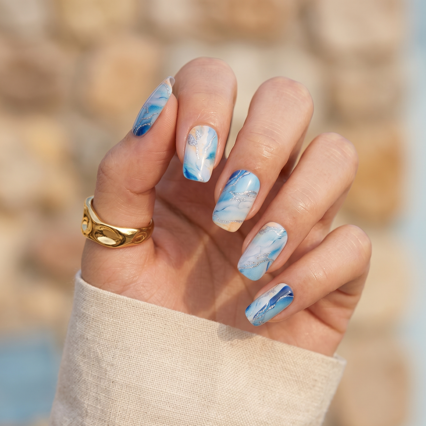 Blue granite marble nail wraps on hand with white swirl patterns non-UV manicure