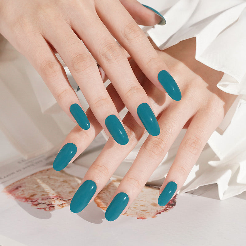 Teal glossy press-on nails, solid colour, medium coffin shape, on layered hands