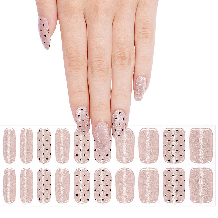 Shimmery nude pink nail wraps with black polka dot accent design, semi-cured gel strips