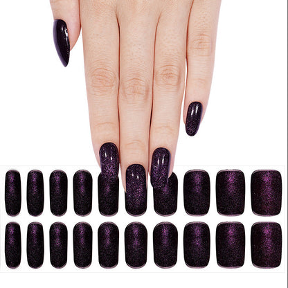 Black nail wraps with purple shimmer, glossy finish, almond-shaped semi-cured gel set.