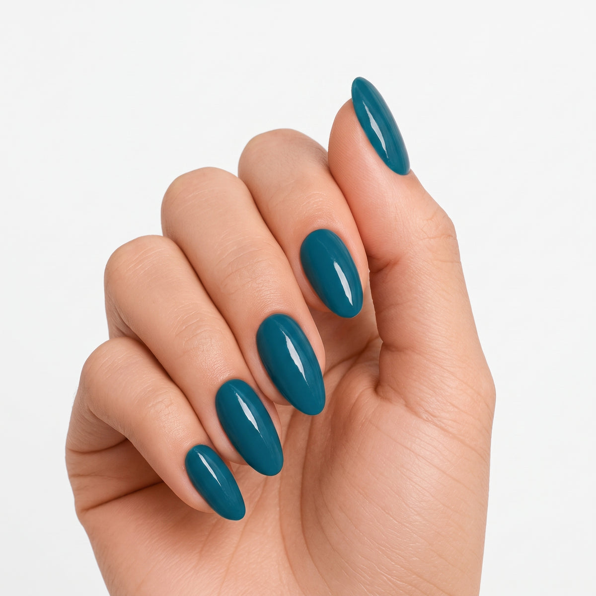 Glossy teal-blue semi-cured gel nail wraps on almond-shaped nails, solid colour finish.