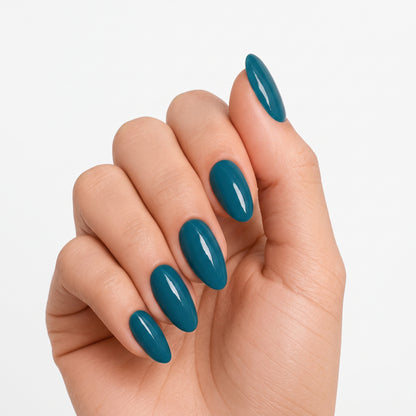 Glossy teal-blue semi-cured gel nail wraps on almond-shaped nails, solid colour finish.