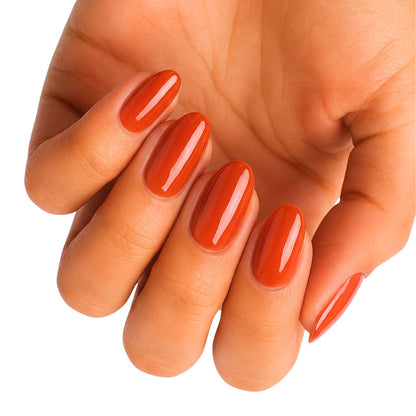 Glossy rust-orange semi-cured gel nail wraps on almond-shaped nails.