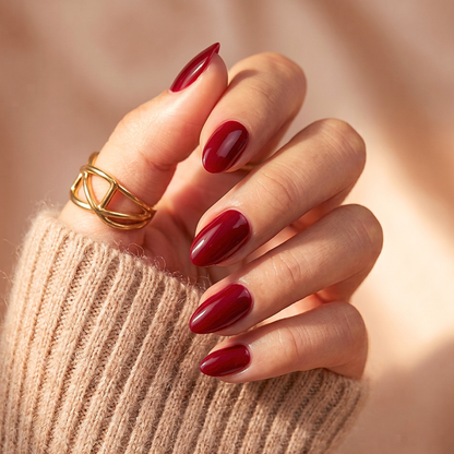 Deep burgundy-red glossy soft gel press-on nails in an almond shape