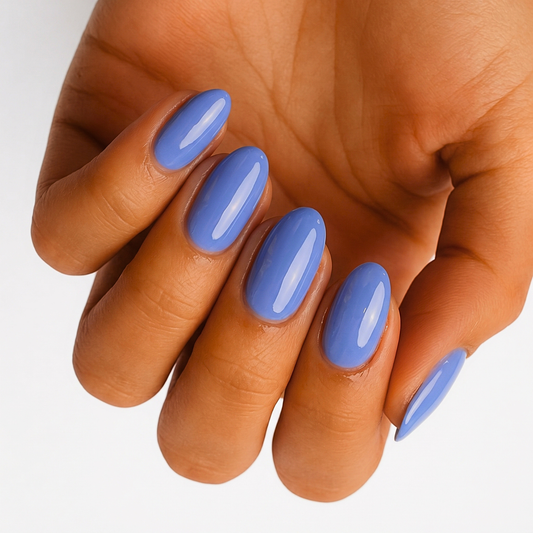Glossy periwinkle blue semi-cured gel nail wraps on almond-shaped nails