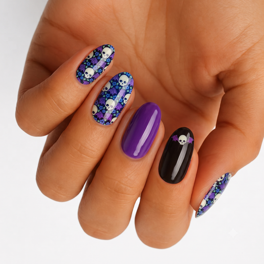 Glossy nail wraps: purple skull-and-bat print, solid purple, and black with bat accent.