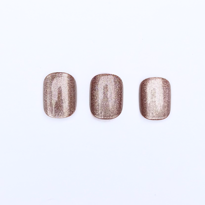 Bronze-gold shimmer press-on nails with metallic finish, square shape, three swatches.