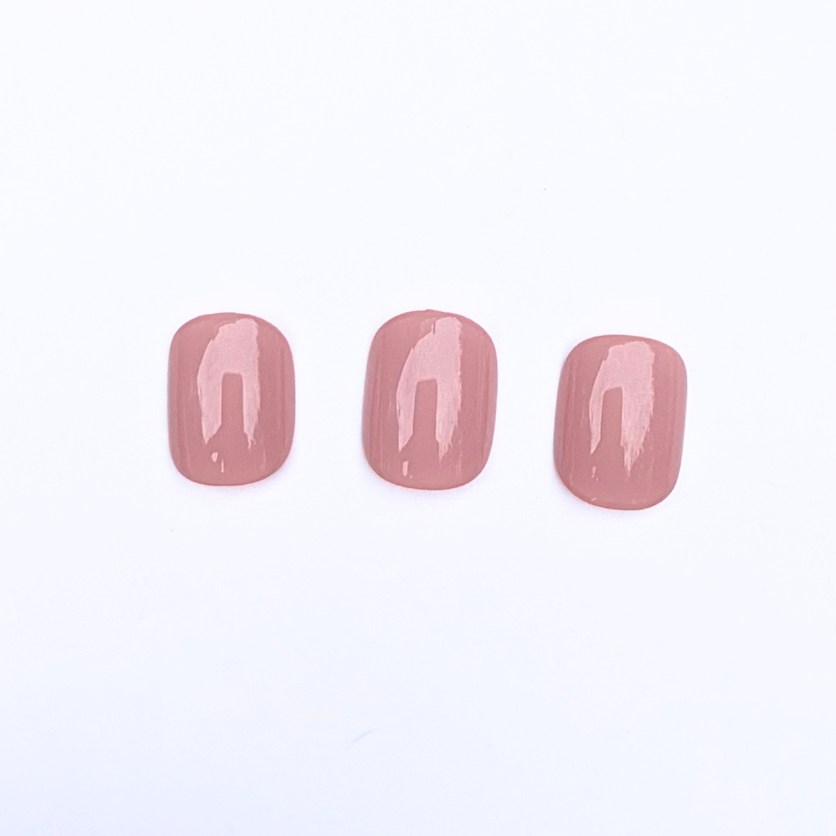 Glossy dusty rose press-on nails, solid mauve-pink finish, square-round shape, set of three.