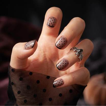 Sheer nude semi-cured gel nail wraps with black polka dots and glossy tip liner