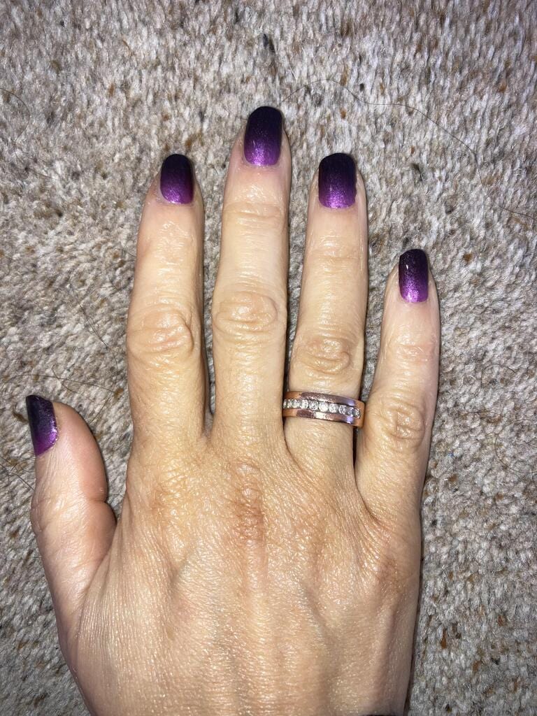 Purple black ombré gradient nail wraps on hand against grey textured background