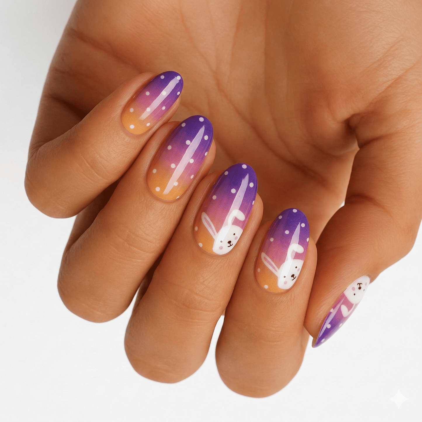 Purple orange gradient nail wraps on hand featuring cute white bunny rabbit Easter designs