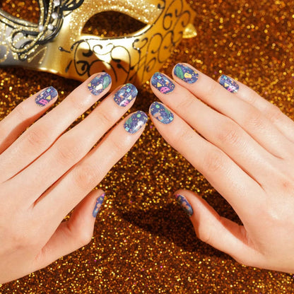 Carnival nail art wraps on hands with colourful geometric patterns and golden carnival mask