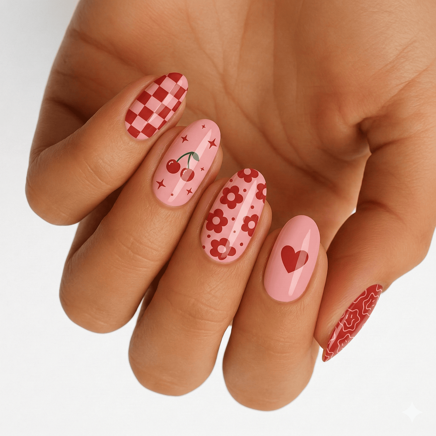 Pink and red nail wraps with cherry and checkerboard patterns on hand
