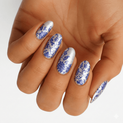 Blue and white porcelain floral nail wraps on hand showing delicate pattern