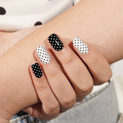 Monochrome dotted gel nail wraps showing black and white polka dot manicure design
