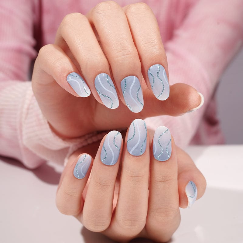 Blue wave marble gel nail wraps displayed on overlapping hands showing pattern detail