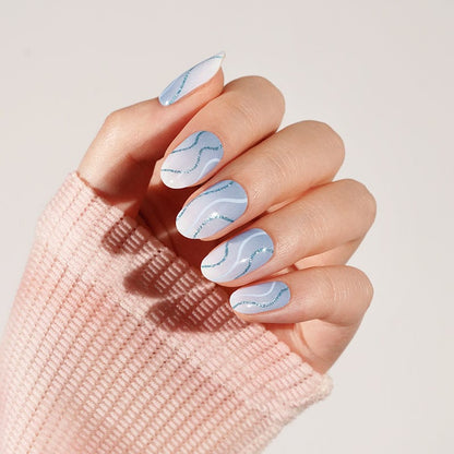 Soft blue marble gel nail wraps with flowing wave design on single hand