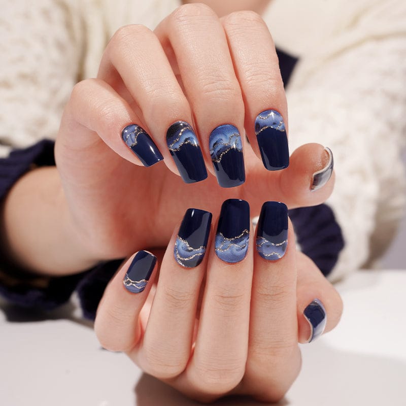 Dark blue gradient gel nails with storm cloud effect shown on both hands